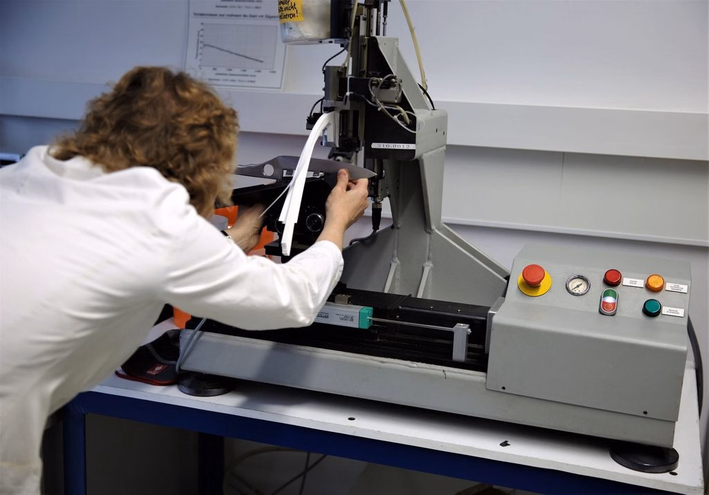 Ensaios mecânicos com corpo de prova posicionado em máquina de ensaio de laboratório